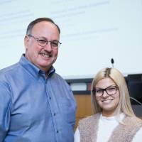A student standing with a donor posing for a photograph.
